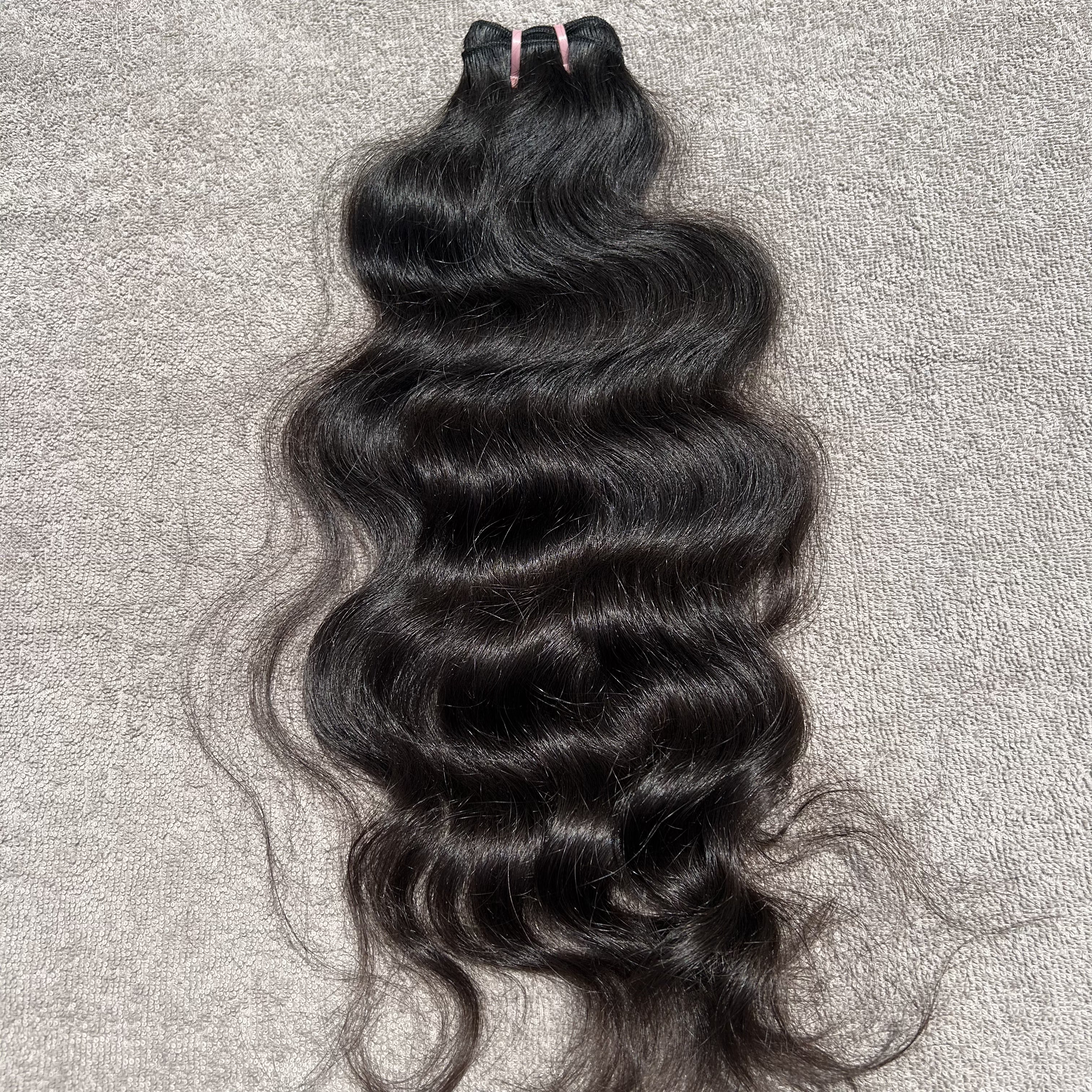 Black wavy hair bundle on a gray textured background